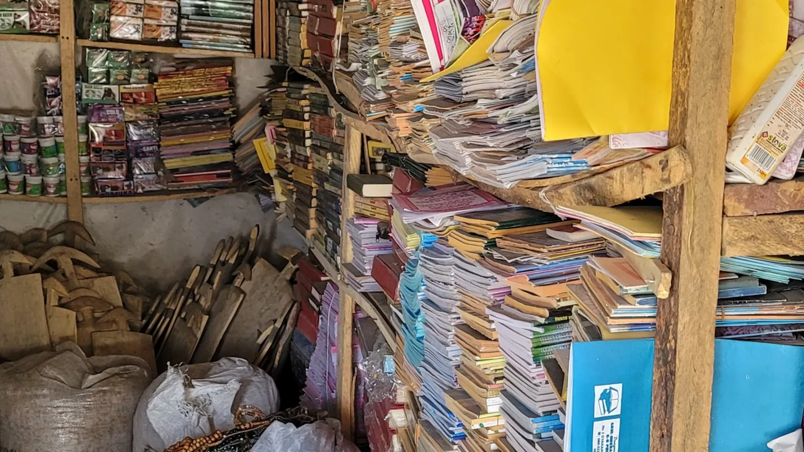 A market stall crammed from floor to ceiling with stacked notebooks and books.